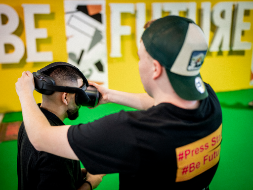 Brille auf! Ein Operator zieht einem Nutzer die VR-Brille an